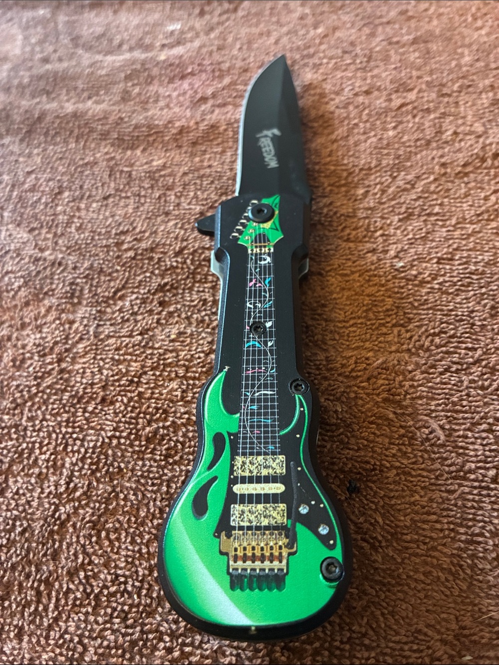 Green Guitar-Style collectible pocket knife.